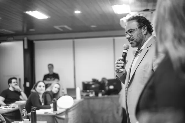 Palestrante com microfone durante evento corporativo