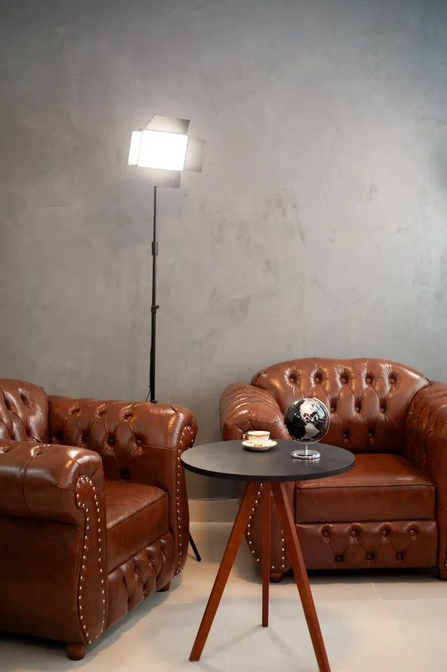 Sala de espera do estúdio com poltronas de couro e iluminação